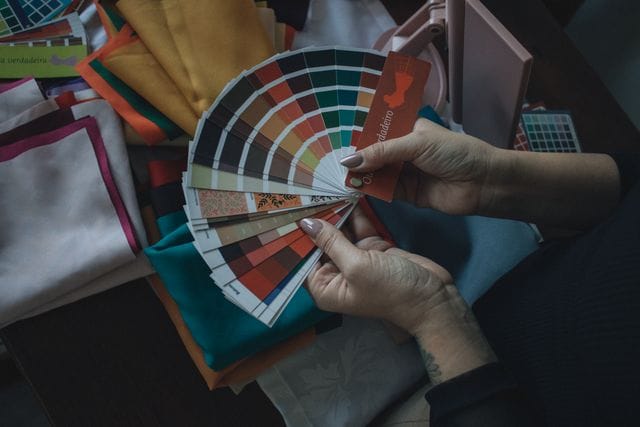 una persona con muestras de colores y telas